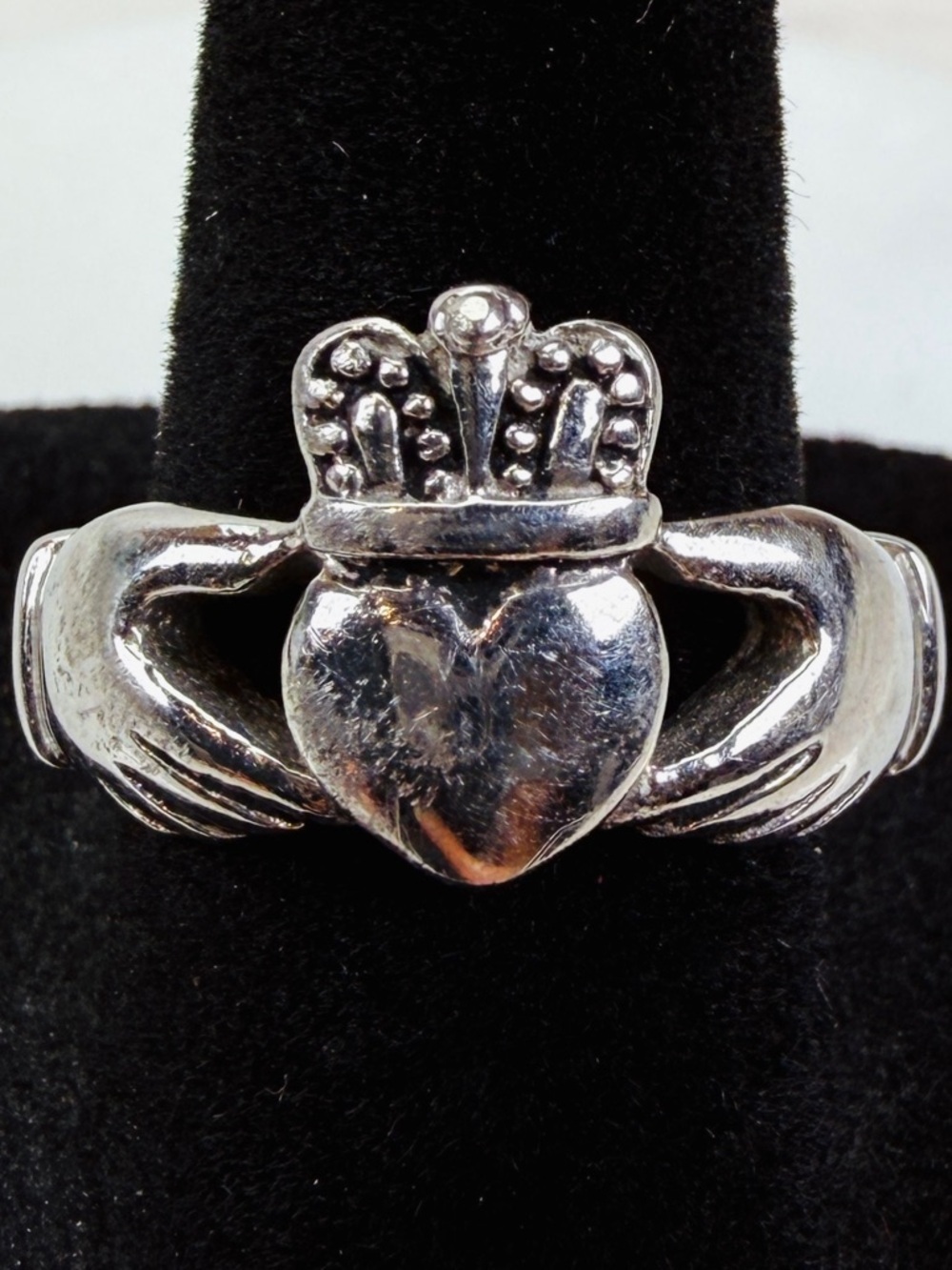 Aged silvertone hands holding heart size 8 ring